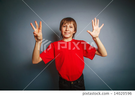 European-looking boy of ten years shows a figure eight finger on 14020596
