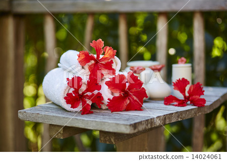 Spa setting with towels and red flowers 14024061
