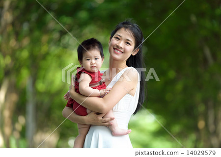 Chinese mother carrying a child in a park 14029579