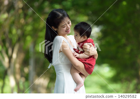 Chinese mother carrying a child in a park Chinese mother carrying a child in a park 14029582