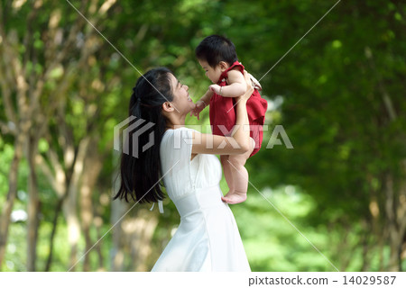 Chinese mother carrying a child in a park 14029587