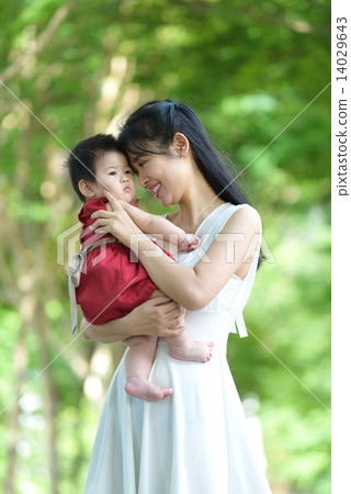 Chinese mother carrying baby in a park 14029643