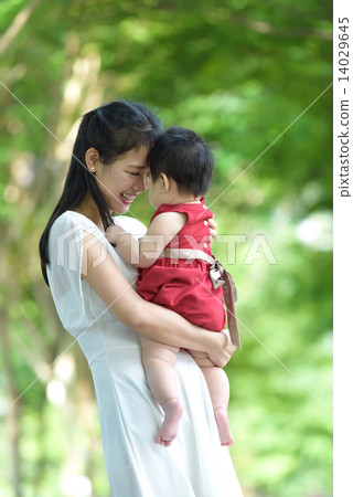 Chinese mother carrying baby in a park 14029645