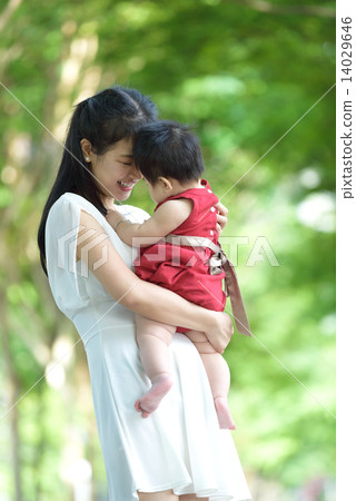 Chinese mother carrying baby in a park 14029646