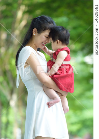 Chinese mother carrying baby in a park 14029661