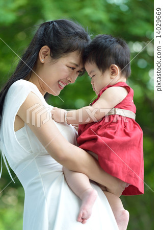Chinese mother carrying baby in a park 14029669