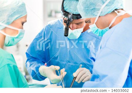 Surgeons operating patient in operation theater 14033002