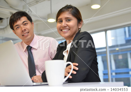 Asian business colleagues working around a laptop 14034553