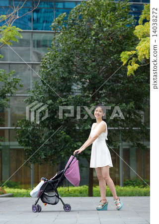 Chinese mother pushing baby stroller in a park Chinese mother pushing baby stroller in a park 14038272