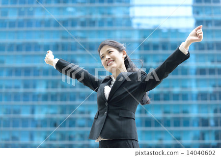 Successful chinese businesswoman celebrating arms in front of blue glass office building Successful chinese businesswoman celebrating arms in front of blue glass office building 14040602