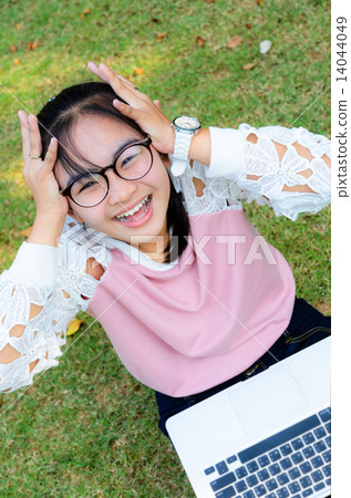 Cute girl is happy with notebook on grass Cute girl is happy with notebook on grass 14044049