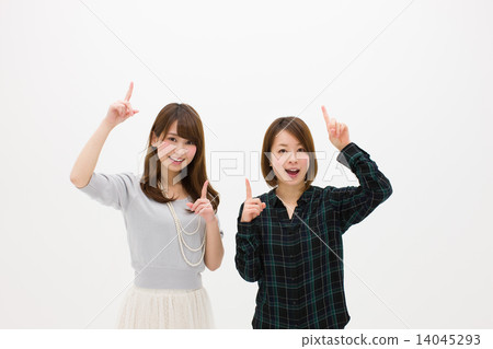 Two young women pointing up with a smile 14045293