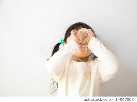 A girl drinking water with a cup A girl drinking water with a cup 14047007