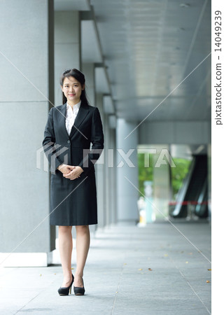 Successful chinese businesswoman along office building walkway Successful chinese businesswoman along office building walkway 14049239