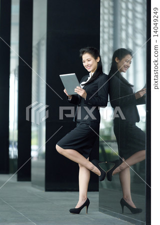 Successful chinese businesswoman using tablet iPad along office promenade Successful chinese businesswoman using tablet iPad along office promenade 14049249