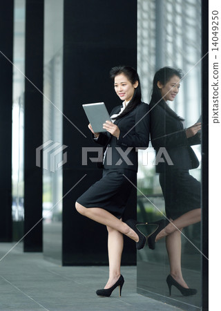 Successful chinese businesswoman using tablet iPad along office promenade 14049250