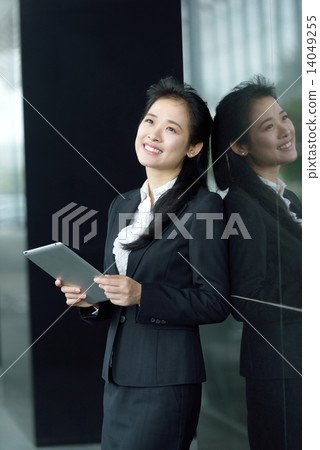Successful chinese businesswoman using tablet iPad along office promenade Successful chinese businesswoman using tablet iPad along office promenade 14049255