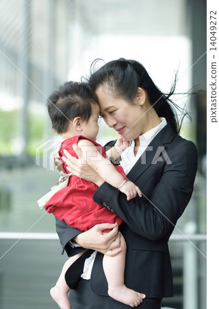 Chinese working mother carrying baby along promenade Chinese working mother carrying baby along promenade 14049272