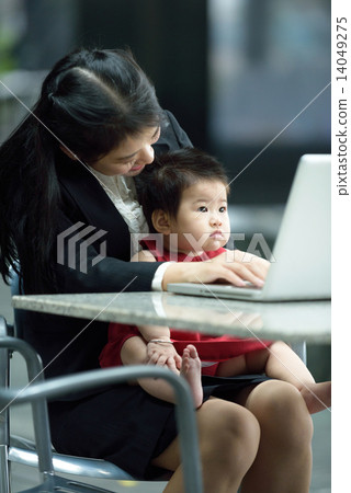Chinese working mother taking care of daughter while using laptop Chinese working mother taking care of daughter while using laptop 14049275