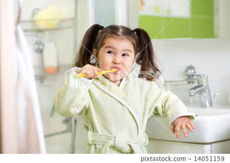 Smiling little girl brushing teeth in bathroom 14051159