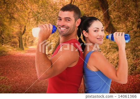 Composite image of fit man and woman smiling at camera together 14061366