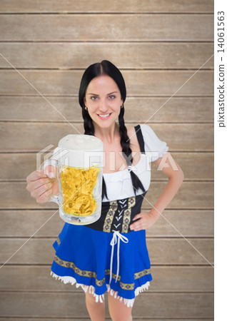 Composite image of pretty oktoberfest girl holding beer tankard 14061563