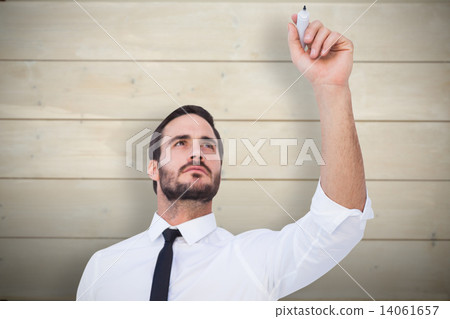 Composite image of focused businessman writing with marker 14061657