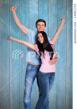 Composite image of young couple cheering at camera Composite image of young couple cheering at camera 14061725