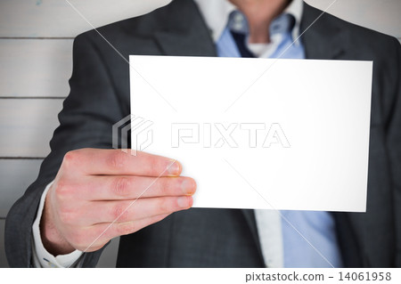 Composite image of businessman in grey suit showing card 14061958