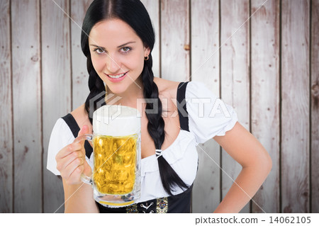 Composite image of pretty oktoberfest girl holding beer tankard 14062105