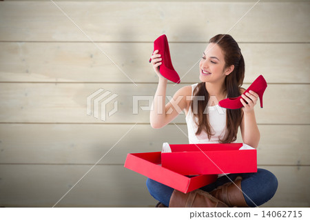 Composite image of content brunette holding red shoes Composite image of content brunette holding red shoes 14062715