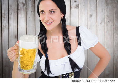 Composite image of pretty oktoberfest girl holding beer tankard 14062726