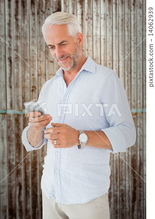 Composite image of smiling man sending a text message Composite image of smiling man sending a text message 14062939