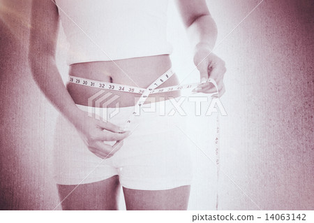 Composite image of midsection of woman measuring waist Composite image of midsection of woman measuring waist 14063142