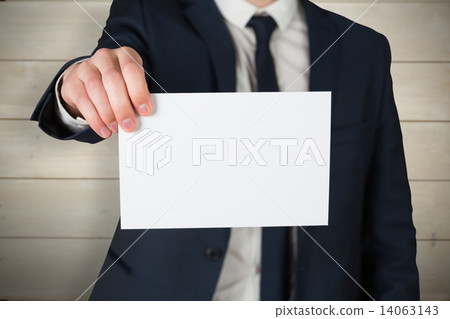 Composite image of businessman showing card to camera Composite image of businessman showing card to camera 14063143