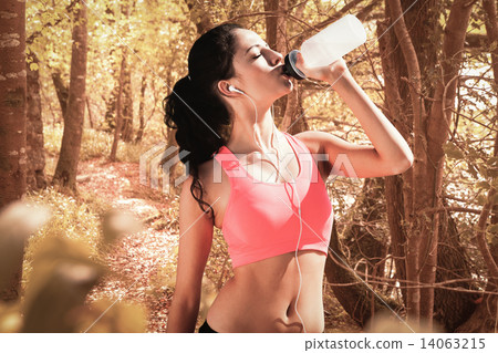 Composite image of beautiful healthy woman drinking water 14063215