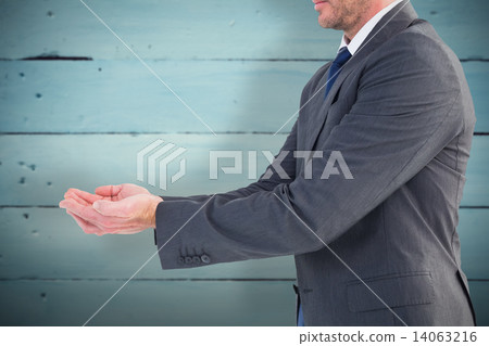 Composite image of businessman holding his hands out 14063216