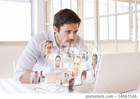 Composite image of businessman working on blueprints and laptop Composite image of businessman working on blueprints and laptop 14063386