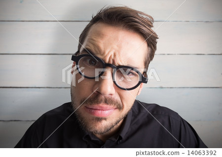 Composite image of portrait of a doubtful businessman with glass Composite image of portrait of a doubtful businessman with glass 14063392