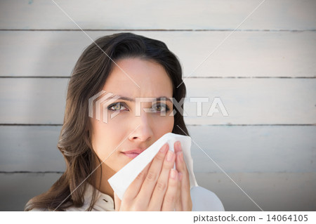 Composite image of brunette with a cold Composite image of brunette with a cold 14064105