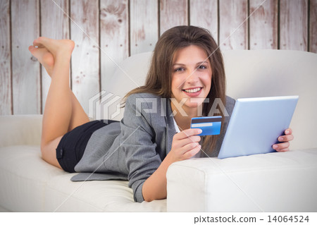 Composite image of woman doing online shopping with tablet and c Composite image of woman doing online shopping with tablet and c 14064524