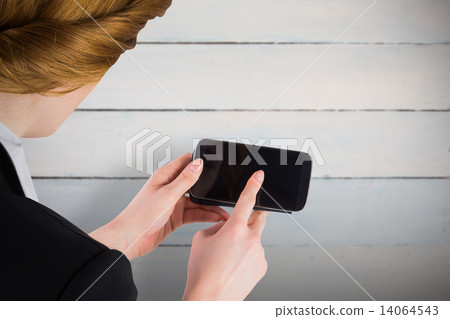 Composite image of businesswoman holding smartphone showing scre Composite image of businesswoman holding smartphone showing scre 14064543