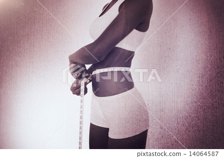 Composite image of young woman measuring her waist during diet Composite image of young woman measuring her waist during diet 14064587