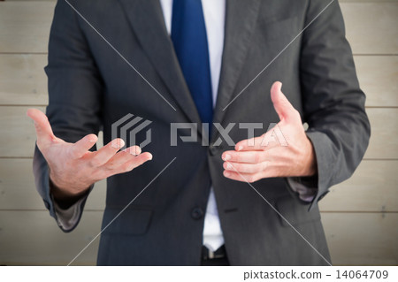 Composite image of handsome businessman presenting with hands 14064709