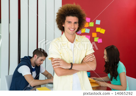 Casual young man with arms crossed in office 14065292