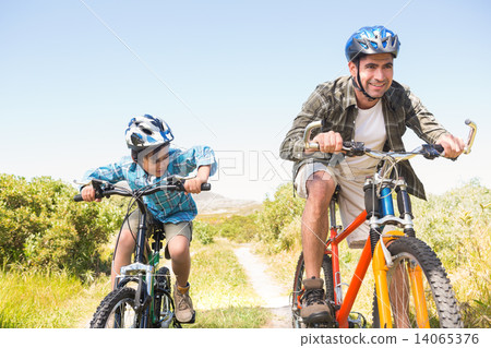 Father and son biking through mountains Father and son biking through mountains 14065376