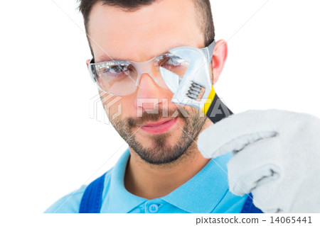 Repairman looking through adjustable wrench 14065441