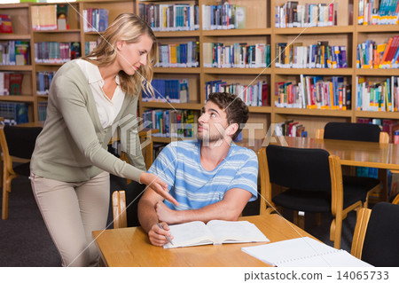 Student getting help from tutor in library 14065733