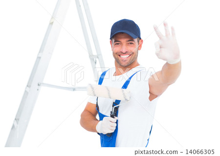 Happy handyman with paint roller gesturing okay 14066305