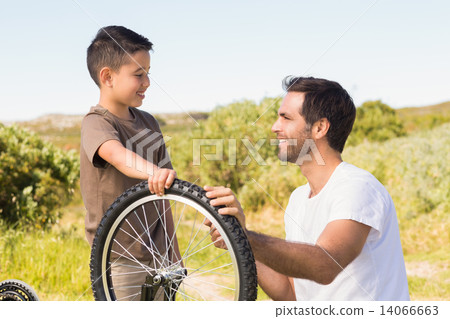 Father and son repairing bike together 14066663